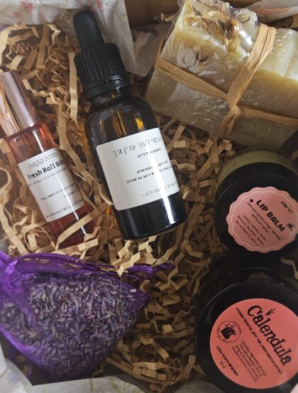 ערכה בקופסה שמכילה את המוצרים- סבון טבעי, שמן עיסוי, מתלה לבנדר, רול פרש, משחת קלנדולה ושפתון טבעי